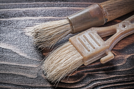Age-old paint brushes on wooden board construction concept.の写真素材