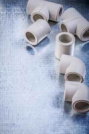 Set of plastic pipe connectors on metallic surface construction concept.の写真素材