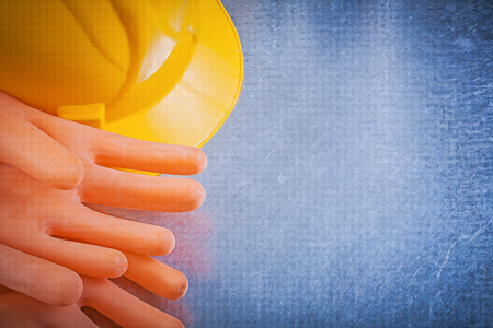 Insulating rubber gloves hard hat on metallic background.の写真素材