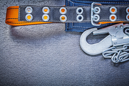 Construction body belt with metal chain on black background maintenance concept.