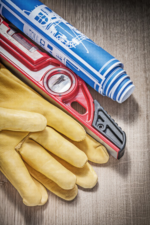 Safety leather gloves construction level drawings on wood board.の写真素材