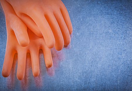 Electricians rubber gloves on metallic background electricity concept.の写真素材