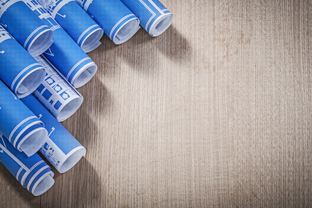 Assortment of blue construction plans on wooden board.