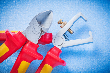 Wire stripper pliers sharp nippers on blue background electricity concept.