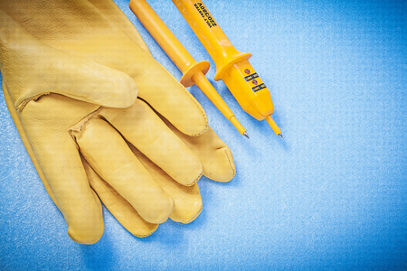 Top view of leather protective gloves electrical tester on blue background electricity concept.の写真素材
