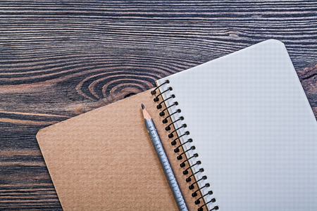 Notepad pencil on vintage wooden board office concept.