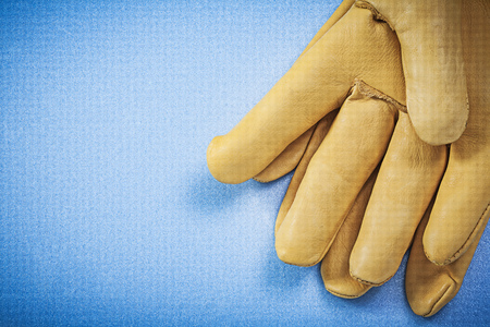 Pair of leather safety gloves on blue background construction concept.の写真素材