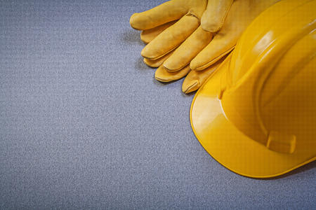 Yellow building helmet leather protective gloves on grey background construction concept.の写真素材