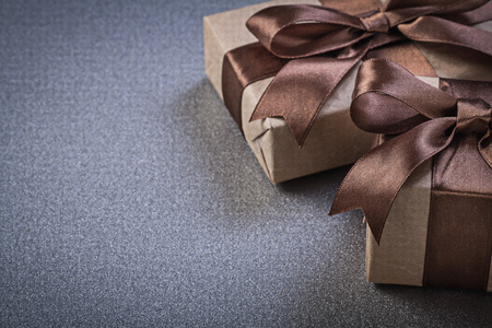 Boxed gifts in brown wrapping paper on grey background celebrations concept.の写真素材