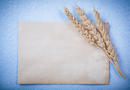 Golden wheat ears vintage paper sheet on blue background.の写真素材
