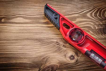 Red construction level on vintage wooden board.の写真素材