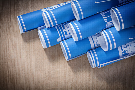 Composition of blue blueprint rolls on wooden board construction concept.