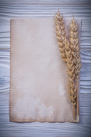 Vintage paper wheat rye ears on wooden board.の写真素材