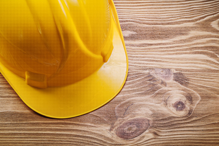 Hard hat on wooden board construction concept.