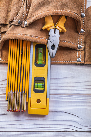 Pliers wooden meter construction level tool belt on wood board maintenance concept.の写真素材