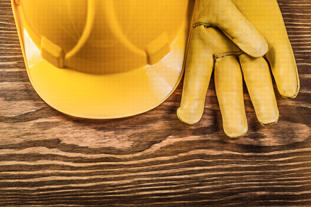 Leather safety gloves building helmet on wooden board construction concept.の写真素材