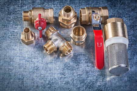 Brass lever ball valve pipe connectors strainer filter on metallic background plumbing concept.の写真素材