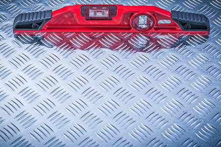 Red construction level on fluted metal plate maintenance concept.