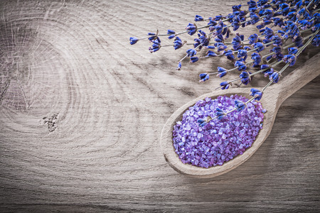 Dry lavender sea salt wooden spoon on wood board spa treatment concept.の写真素材