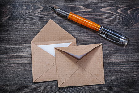 Collection of vintage post envelopes fountain pen on wooden board.
