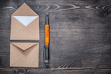 Vintage post envelopes fountain pen on wooden board copyspace.