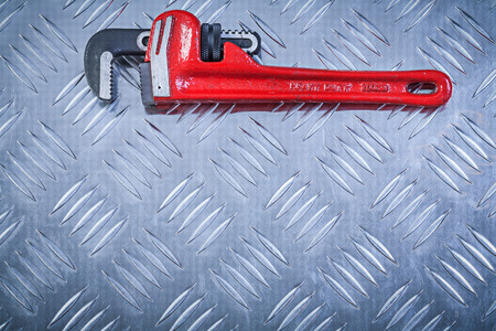 Adjustable monkey spanner on channeled metal background construction concept.の写真素材