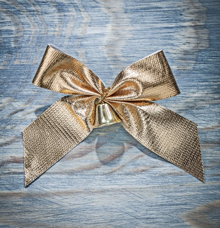 Golden Christmas bow on wooden board celebrations concept.の写真素材