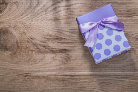 Wrapped present box with tape on wooden board celebrations concept.