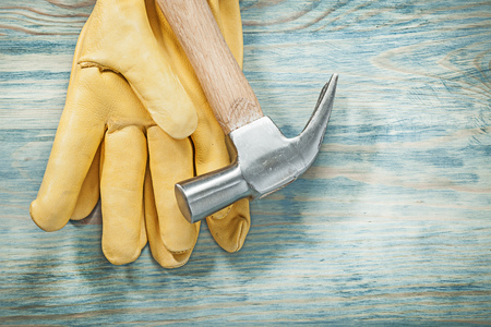 Claw hammer yellow protective gloves on wood board construction concept.