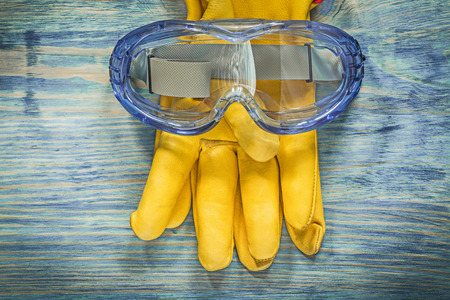 Safety leather gloves goggles on wooden board construction concept.の写真素材