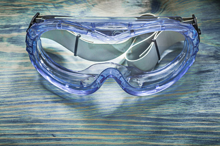 Safety glasses on wooden board construction concept.