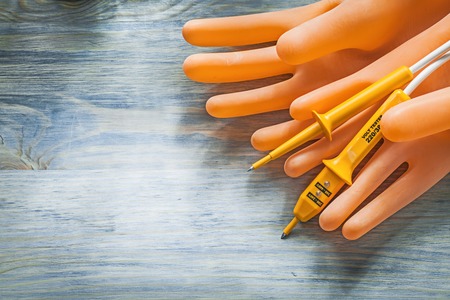 Electric tester dielectric gloves on wooden board electricity concept.の写真素材