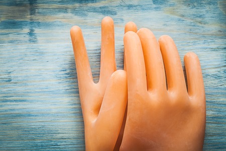 Dielectric gloves on wooden board electricity concept.の写真素材
