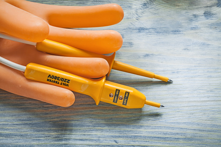 Electric tester dielectric rubber gloves on wood board electricity concept.の写真素材