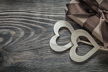 Present box white wooden hearts on vintage wood board holidays concept.の写真素材