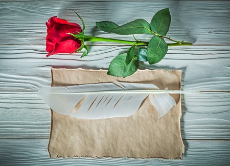 Natural red rose vintage paper sheet plume on wooden board holidays concept.の写真素材