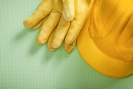 Yellow building helmet protective gloves on green background construction concept.の写真素材