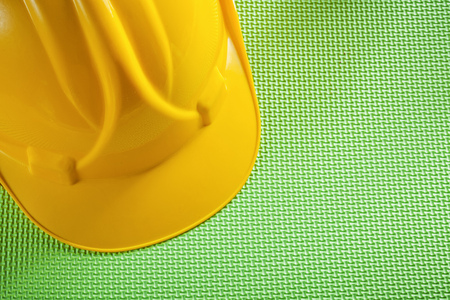 Yellow building helmet on green background construction concept.の写真素材