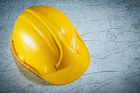 Building helmet on metallic surface construction concept.