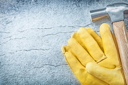 Set of leather safety gloves claw hammer on metallic background construction concept.