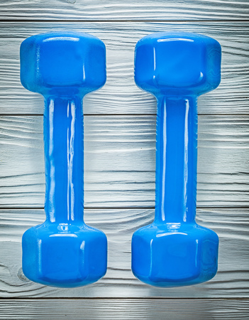 Pair of dumb-bells on wooden board top view sports training concept.の写真素材