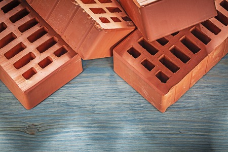 Collection of orange bricks on wooden board construction concept.