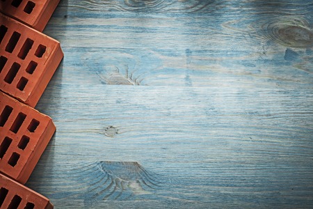 Set of red building bricks on wood board copy space bricklaying concept.の写真素材