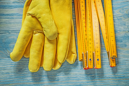 Wooden meter leather protective gloves on wood board construction concept.
