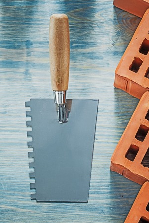 Plastering trowel red bricks on wood board bricklaying concept.の写真素材