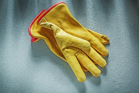 Leather working gloves on concrete background construction concept.