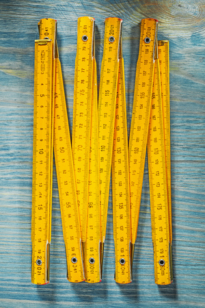 Yellow wooden meter on vintage wood background vertical image construction concept.