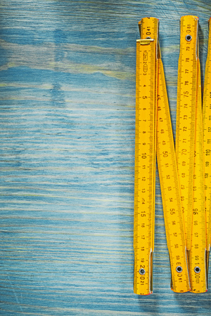 Yellow wooden meter on vintage wood surface construction concept.の写真素材