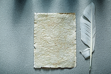 Medieval crumpled paper sheet plume on grey background.の写真素材