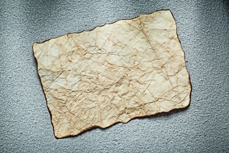 Vintage crumpled sheet of paper on grey surface.の写真素材